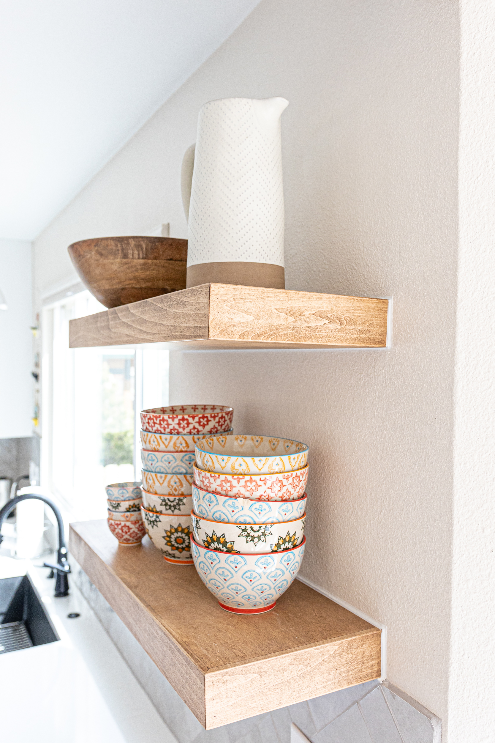 Open wooden kitchen shelves with decorative dishes